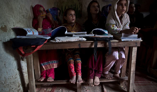 In this Tuesday, Sept. 23, 2014, photo, Afghan refugees and internally displaced Pakistani school children attend their classes at a makeshift school on the outskirts of Islamabad, Pakistan. (AP)