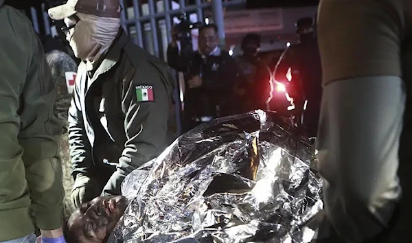 Paramedics carry a migrant who was wounded in a deadly fire at an immigration detention center in Ciudad Juarez, Mexico, Tuesday, March 28, 2023. (AP)