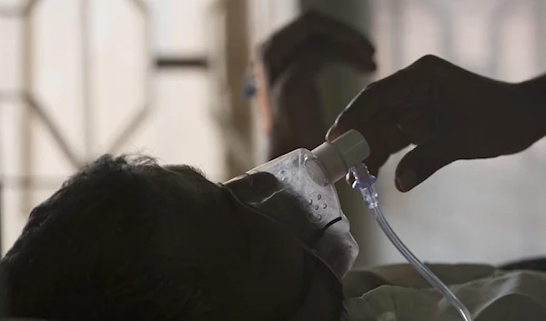 =A relative adjusts the oxygen mask of a tuberculosis patient at a TB hospital on World Tuberculosis Day in Hyderabad, India. (AP)