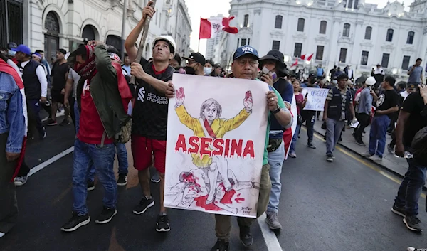 Supporters of ousted President Pedro Castillo hold a poster depicting Peru's new president, Dina Boluarte, along with sign "Killer" during a protest in Lima, Peru, Monday, Dec. 12, 2022. (AP)