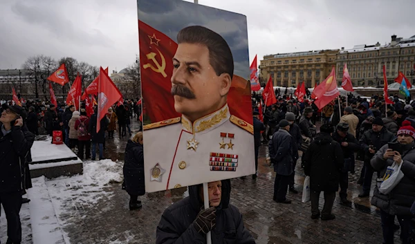 Communist party supporters with red flags and a portrait of Josef Stalin gather at the Historical Museum to place flowers at his grave near the Kremlin Wall to mark the 70th anniversary of his death in Red Square in Moscow, Russia, March 5, 2023 (AP Photo)