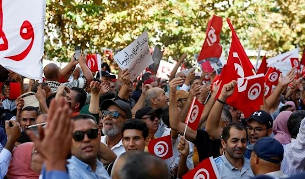 Tunisians carry signs and flags during a protest against Tunisian President in Tunis, Tunisia October 15, 2022. (REUTERS)