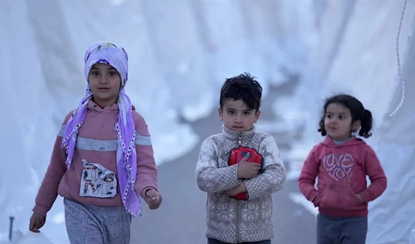 Over 850,000 children stilChildren walk between tents, in Aslanli, southeastern Turkey, Thursday, Feb. 9, 2023. (AP)