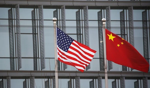 The US and Chinese flags standing outside an American company in China in January 2021 (Reuters)