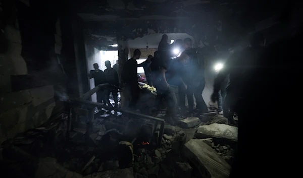 Palestinians inspect the site of a building damaged in an Israeli military raid in the West Bank refugee camp of Jenin, Tuesday, March 7, 2023. (AP)