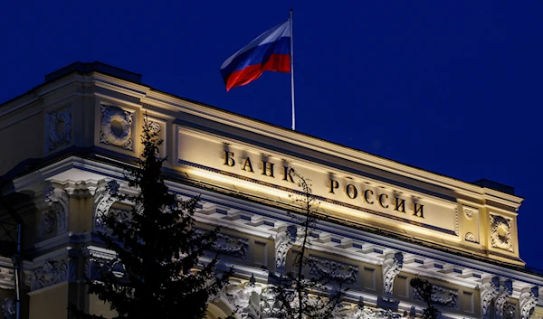 A view of the Bank of Russia at night with the Russian flag in May 2022 (Reuters)