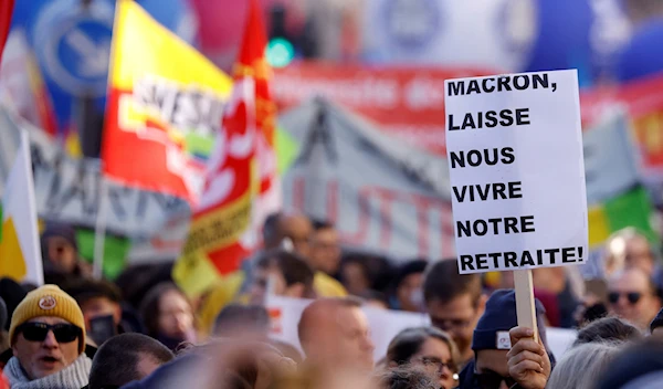 Protesters during a protest against French government's pension reform plan in Paris, France, February 7, 2023, with the placard reading:"Macron, let us live our retirement"