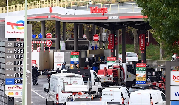 Cars and motorcycles queue for fuel at a gas station in Paris on October 13, 2022 (AFP)