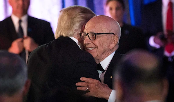 Rupert Murdoch and Donald Trump embracing at during a dinner to commemorate the 75th anniversary of the Battle of the Coral Sea during WWII onboard the Intrepid Sea, Air and Space Museum May 4, 2017 in New York (AFP)