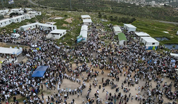 Israeli settlers gather in the outpost of Evyatar in the West Bank, occupied Palestine, April 10, 2023 (AP)