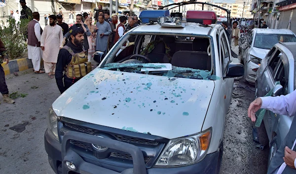 Police officers examine a damaged police vehicle at the site of bomb blast, in Quetta, Pakistan, April 10, 2023 (AP)