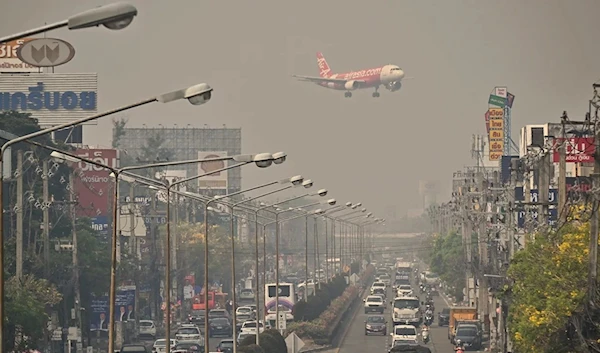 An Air Asia plane prepares to land in Chiang Mai International Airport in the heavily polluted but busy Thai city, 10 April 2023. (AFP)