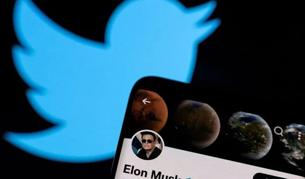 Elon Musk's Twitter account is seen on a smartphone in front of the Twitter logo in this photo illustration taken, April 15, 2022. (REUTERS)