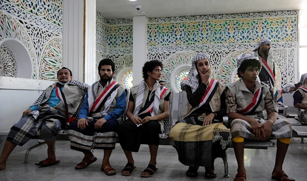 Yemeni prisoners sit after they landed at Sanaa airport, April 14, 2023 (AP)