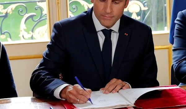 French President Emmanuel signs documents that will promulgate a new labor bill in hiss office at the Elysee Palace, Paris, France, 22 September 2017. (Reuters)