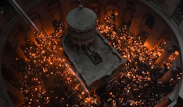 Christian pilgrims hold candles during the Holy Fire ceremony, a day before Easter, at the Church of the Holy Sepulcher, where many Christians believe Jesus was crucified, buried and resurrected, in Jerusalem's Old City, Saturday, April 15, 2023. (AP)