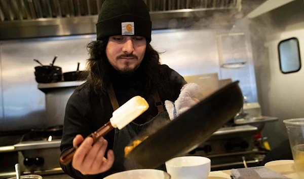 Santos Enrique Camara, 27, who dropped out of Shoreline Community College at age 19 in 2015, prepares food at Capers + Olives Friday, March 24, 2023, in Everett, Wash. (AP)