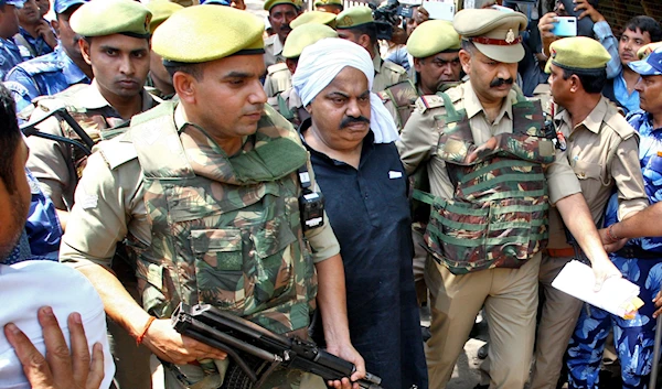 Police officers escort Atiq Ahmed, a former lawmaker in India's parliament, accused in several criminal cases, outside a court in Prayagraj on April 13, 2023.( Reuters)