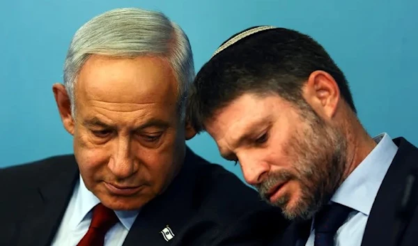 The Occupation's Finance Minister, Bezalel Smotrich talks his Prime Minister Benjamin Netanyahu at a press conference at the Prime Minister's office in occupied Al-Quds, 25 January 2023. (Reuters)