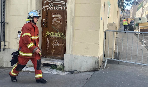 A firefighter walks near the scene where a building collapsed, in Marseille, southern France, April 10, 2023. (AP)