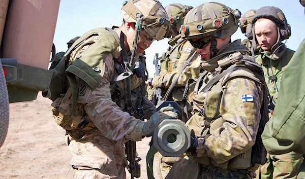 American soldier shows soldier from the Finnish Army an AT-4 anti-armor weapon. (US army)