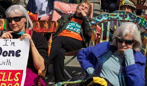 Demonstrators listen to speakers from the Sierra Club local Virginia Chapter speak during a rocking-chair vigil rally demanding banks to stop funding fossil fuel projects at Franklin Park, in Washington, U.S., March 21, 2023.(Reuters)