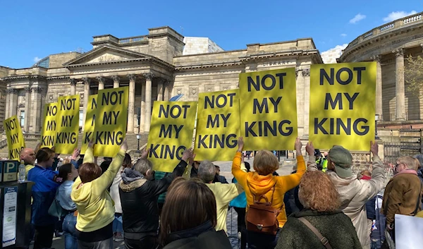 Republic supporters hold up signs that read "NOT MY KING" as they protest in front of the Museum of Liverpool where King Charles is scheduled to arrive, 26 April 2023. (@RepublicStaff/Twitter)