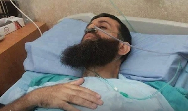 Administrative Palestinian prisoner Sheikh Khader Adnan lies in a hospital bed amid a difficult medical situation as he continues his open hunger strike. (Social media)