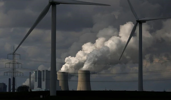 Wind turbines are seen in front of a coal power plant of German utility RWE Power near the western town of Neurath February 28, 2014 (Reuters)