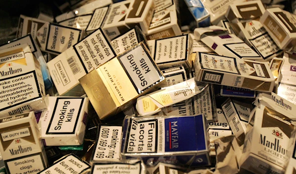 In this Jan. 4, 2007 file photo, discarded cigarette cartons lie on the floor as people gather at a one hour " Stop Smoking" promotion in a bar in central London. (AP)