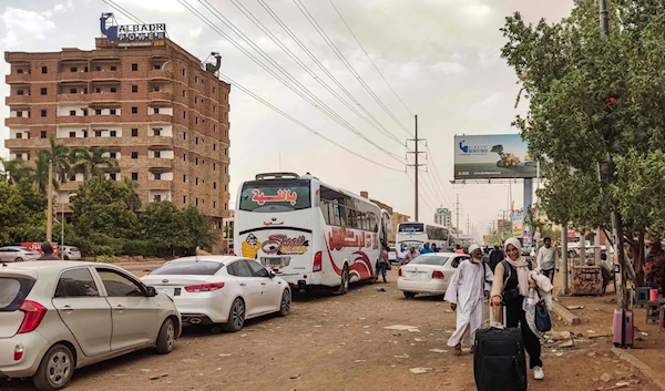 People prepare to board a bus departing from Khartoum in the Sudanese capital's south on April 24, 2023, as battles rage in the city between the army and paramilitaries (AFP)