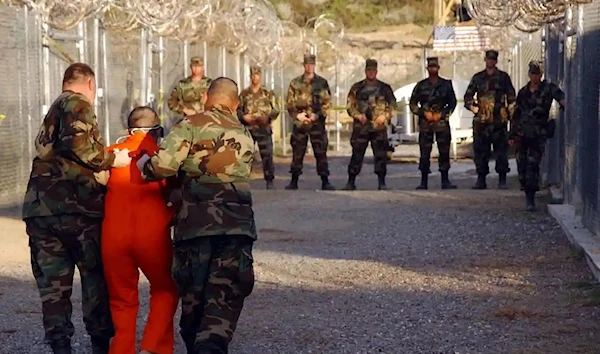 US Army military police escort a detainee to his cell in Camp X-Ray at Guantánamo Bay, Cuba, in 2002. Photograph: Reuters