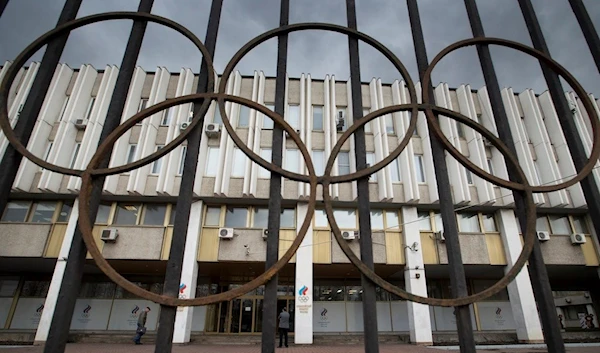 People walk in front of the Russian Olympic Committee building in Moscow, Nov. 13, 2015 (AP Photo/Pavel Golovkin, File)