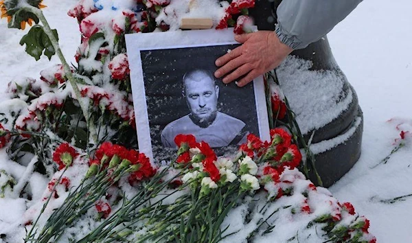 A portrait of Vladlen Tatarsky, who was assassinated in a cafe, is placed near the blast site with flowers in Saint Petersburg, Russia, 3 April 2023. (Reuters)