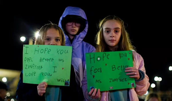 Willow Crawford, left, her sister Ava, right, and friend Kaylynn Vestre show support for Richneck Elementary School teacher Abby Zwerner during a vigil in Newport News, Va., Jan. 9, 2023 (AP)