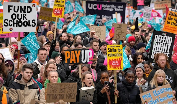 Thousands of teachers wave banners in protest, demanding wage increases, near Downing Street in Westminster in London, Wednesday, Feb. 1, 2023. (AP)