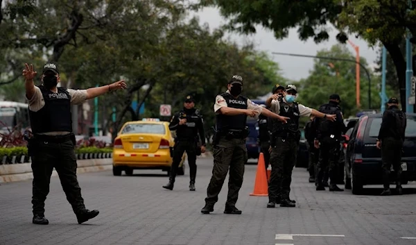 Police officers search oncoming traffic for weapons and drugs at a pop up checkpoint, Guayaquil, Ecuador, 14 December 2021. (Reuters)