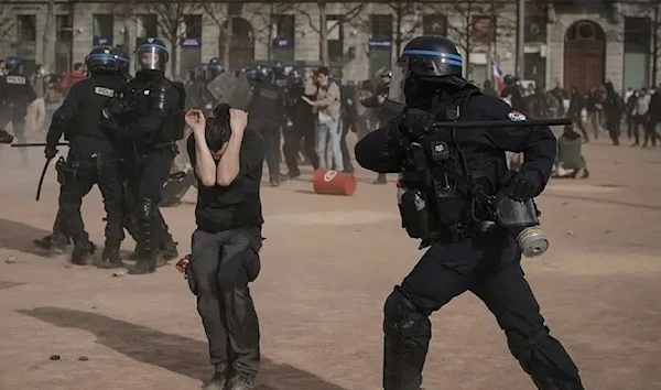 Police officers scuffle with protesters during a demonstration in Lyon, central France, on March 23, 2023. (AP)