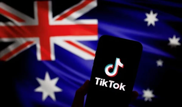 Logo of the Chinese app TikTok displayed on a phone in front of the Australian flag, 4 April 2023. (Reuters)