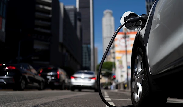 An electric vehicle is plugged into a charger in Los Angeles, California, August 25, 2022 (AP)