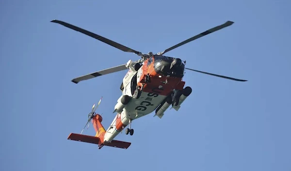 A U.S. Coast Guard helicopter flies over the Venice Fishing Pier Thursday morning, April 6, 2023, as emergency crews search a debris field in the Gulf of Mexico after a small airplane crash Wednesday night (AP)