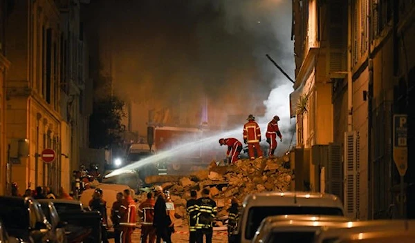 Rescue personnel work at the scene where a building collapsed in Marseille, France, April 9, 2023 (AFP)