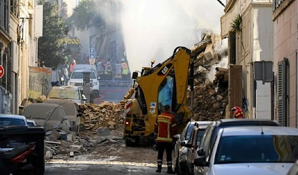 Rescue personnel work at the scene where a building collapsed in Marseille, France, April 9, 2023 (AFP)