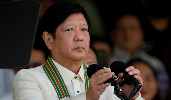 Philippine President Ferdinand Marcos Jr. arranges the mic before speaking at the 126th founding anniversary of the Philippine Army at Fort Bonifacio in Taguig, Philippines on Wednesday, March 22, 2023. (AP)