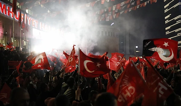 Supporters of the Republican People's Party, CHP, wave Turkish flags, and one with a portrait of Kemal Ataturk, right, as they celebrate after preliminary results of the local elections were announced in Ankara, Turkey, April 1, 2019. (AP)