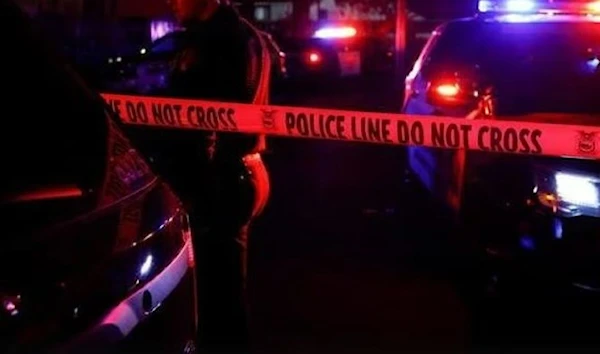 Generic and blurry police lights from a cruiser vehicle and car headlights behind yellow crime scene do not cross caution tape at night. (Reuters)