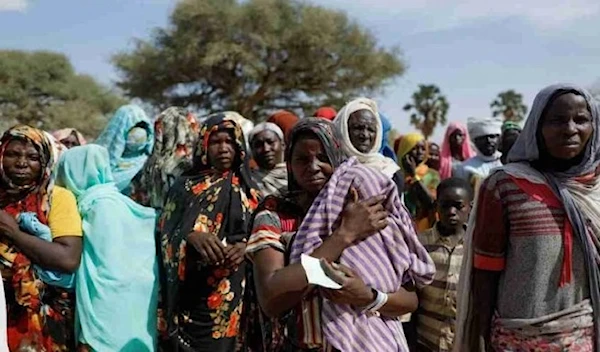 Sudanese refugees, who fled the violence in their country, wait to receive food supplies on 7, 2023. (Reuters)