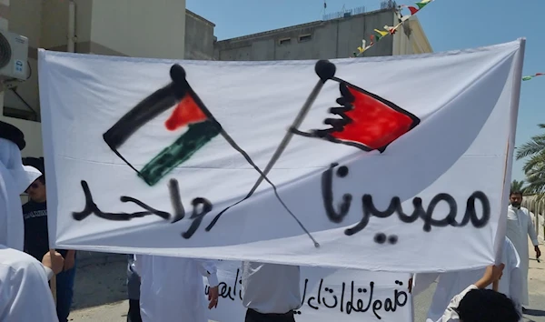 Protesters hold a banner displaying the Palestinian and Bahraini flag which reads out "We share the same fate" in Arabic, Manama, Bahrain, 12 May 2023. (@ALWEFAQ/Twitter)