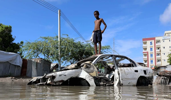 A Somali boy stands on a junk vehicle after heavy rain flooded their neighbourhood in Mogadishu, Somalia, 21 October, 2019. (Reuters)