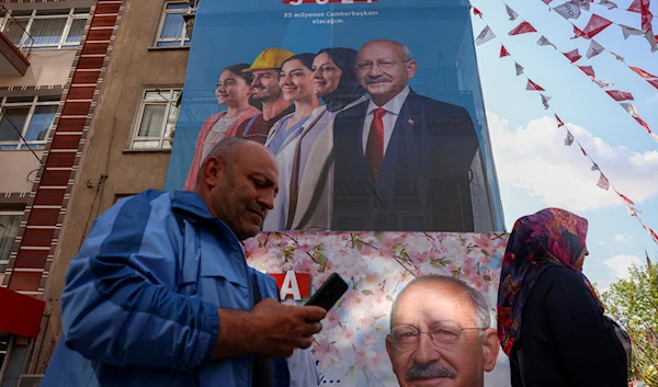 People walk past banners of Kemal Kilicdaroglu, presidential candidate of Turkey's main opposition alliance, in Ankara, Turkey, on May 13, 2023 (Reuters)